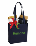 Navy tote bag with 'Humana' branding, filled with office supplies and a gift, on a white background.