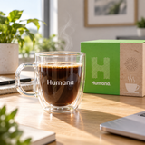 Humana double-wall glass coffee mug filled with coffee in a modern office